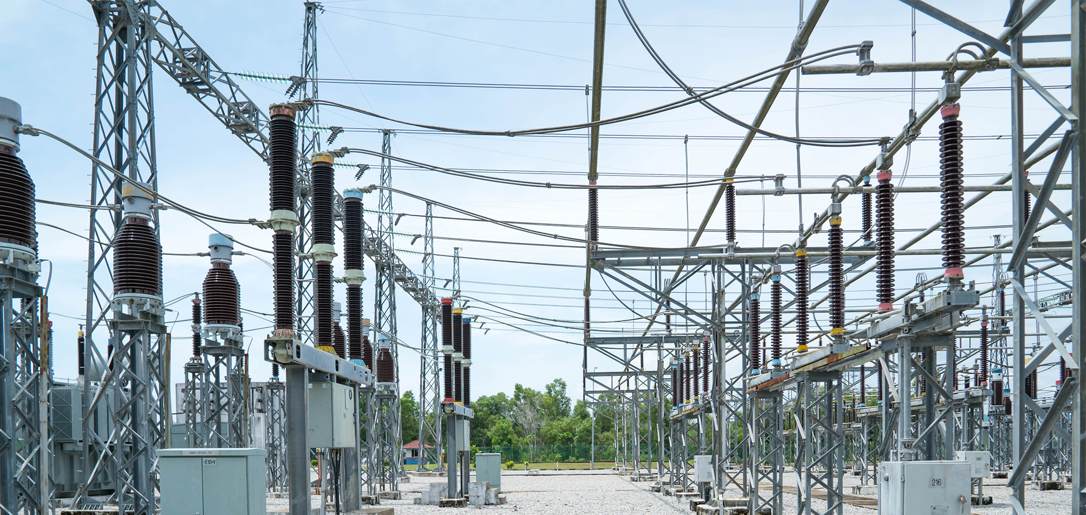 A high-voltage substation switchyard featuring large power transformers, circuit breakers, and lightning arresters for regional grid interconnection.