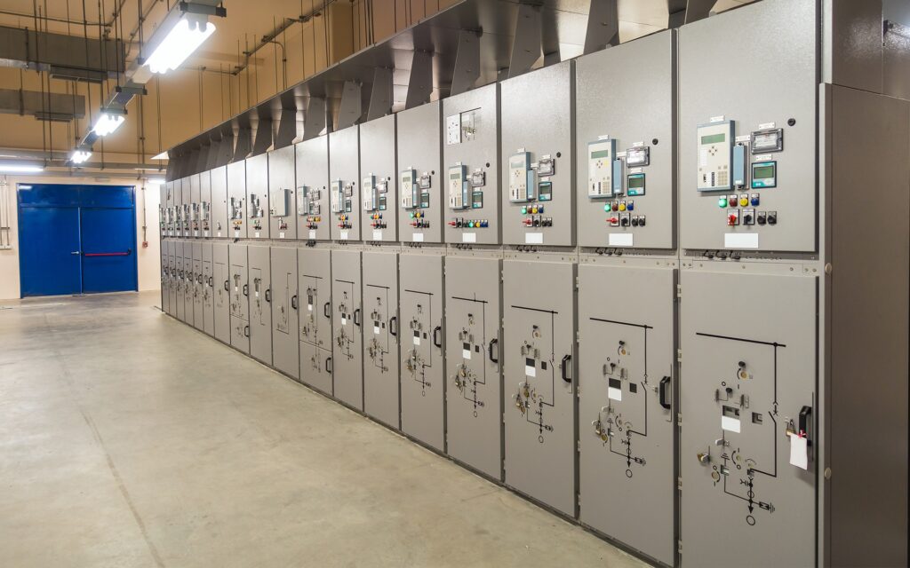 A professional medium voltage distribution system showing multiple switchgear cubicles with protective relays and circuit breakers for industrial power control.