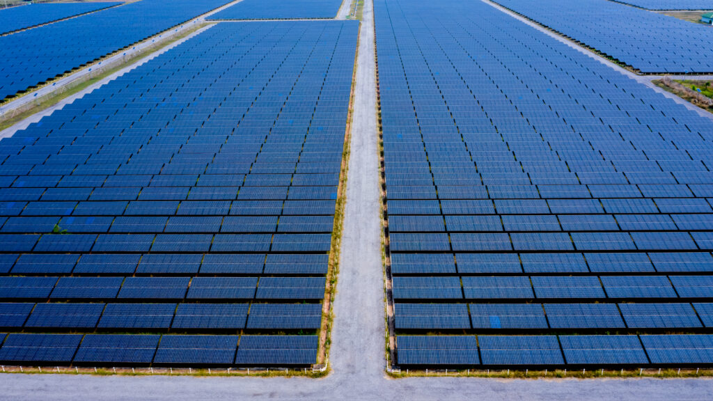 Rows of large-scale monocrystalline solar panels in a utility power plant featuring bifacial module technology and a horizontal single-axis tracking system.