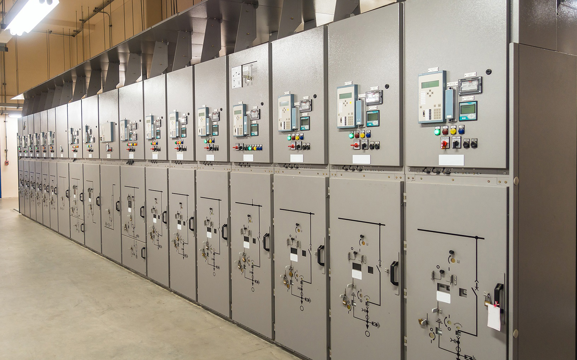 A professional medium voltage distribution system showing multiple switchgear cubicles with protective relays and circuit breakers for industrial power control.