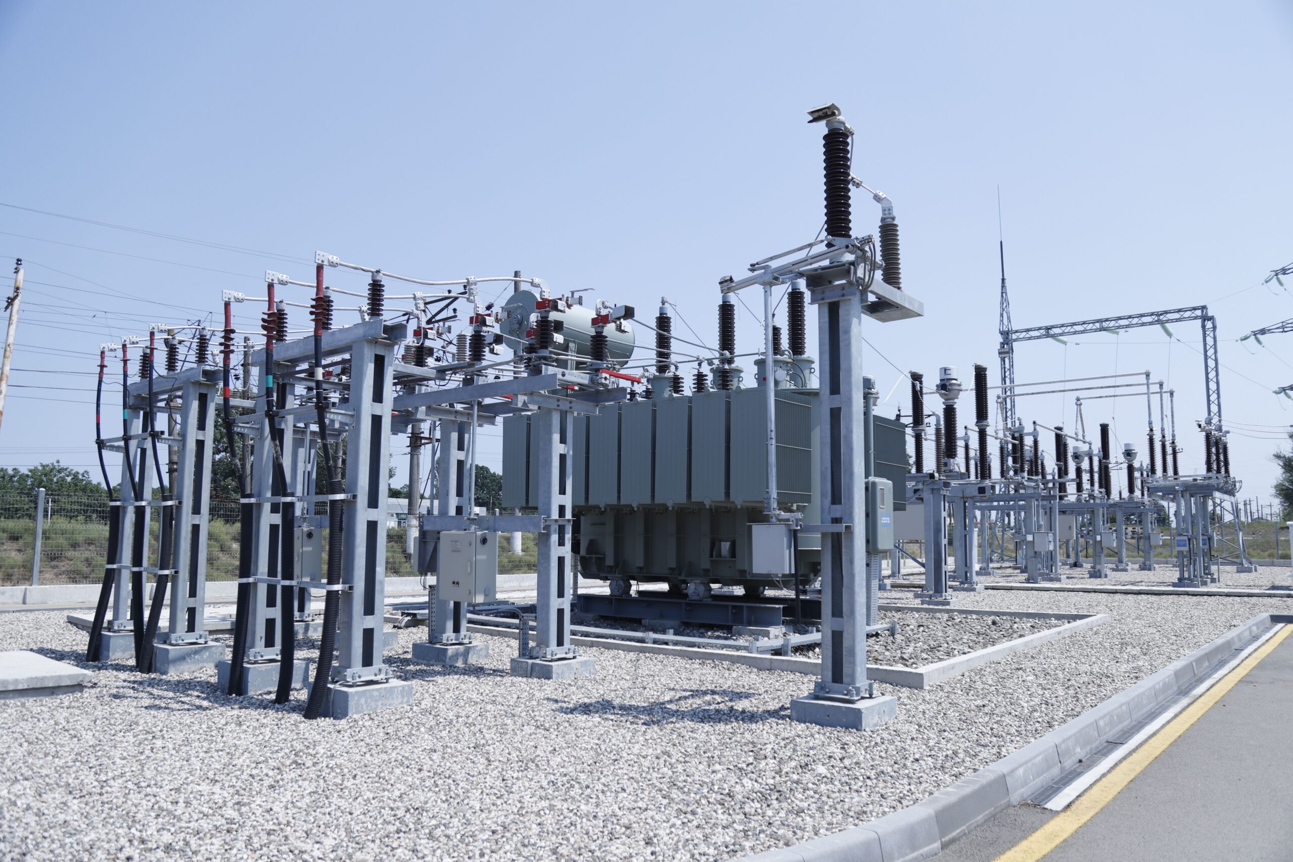 An outdoor AIS substation featuring air-insulated busbars, disconnectors, and power transformers under a clear sky.