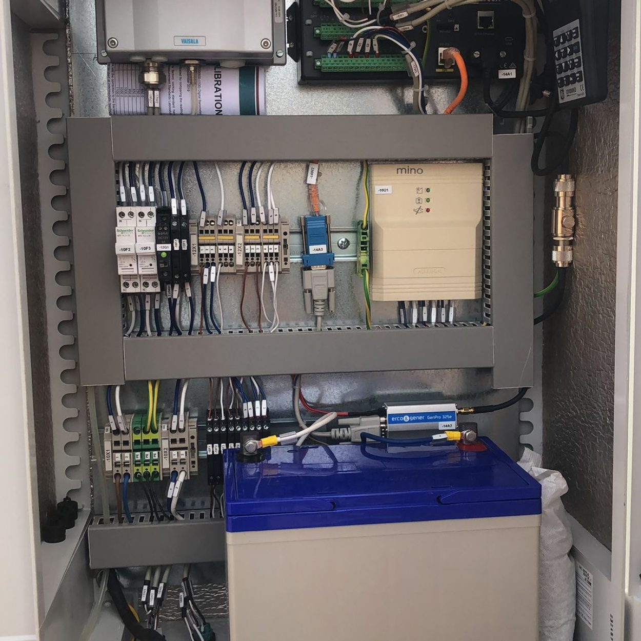 Interior view of a weather station junction box with organized electrical wires, data logger terminals, and surge protection.